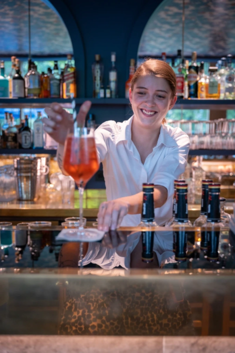 Barkeeperin bereitet Aperol Spritz hinter der Bar des Fräulein Wagners zu.